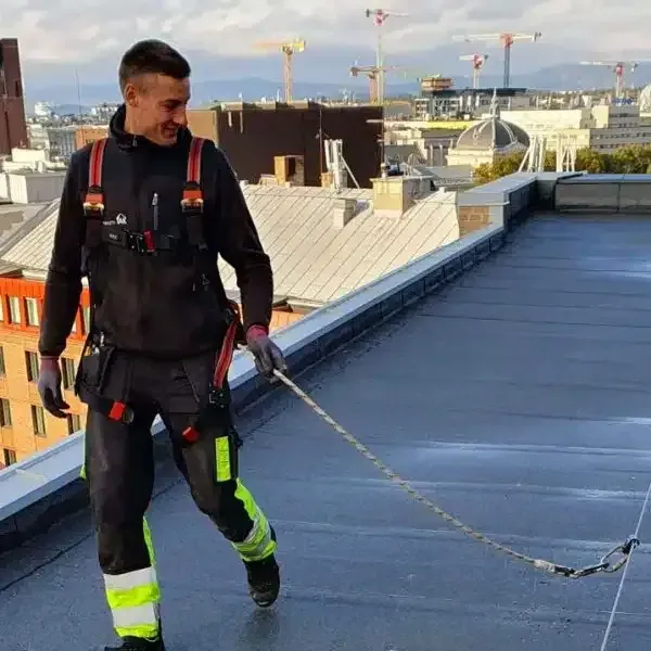 Tekniker fra Fallsikkerhet.no på tag med sikkerhedssele i Oslo