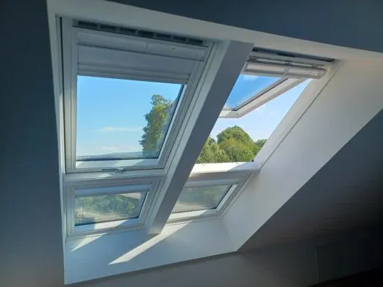Lyst rum med fire VELUX vinduer der åbner mod naturen